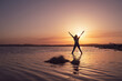 © Javier De La Torre/ADDICTIVE STOCK - Full body back view of unrecognizable slim female in activewear standing in Five Pointed Star Pose with arms up in lake water while practicing yoga during sunset