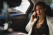 © M√úR/ADDICTIVE STOCK - Busy female entrepreneur sitting in luxury car speaking on mobile phone working