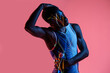 © Manuel Ruiz/ADDICTIVE STOCK - Professional young African American sportsman in active wear performing stretching exercise during training in studio with colorful background and neon lights with eyes closed
