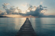© Victor Prieto/ADDICTIVE STOCK - unrecognizable person silhouette standing on spectacular scenery of calm sea with wooden quay under cloudy sky during sundown in Playa de Alcudia