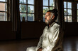 © David Fuentes/ADDICTIVE STOCK - Senior man practicing chi kung meditation in lotus position in studio