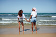 © Jose Luis CARRASCOSA/ADDICTIVE STOCK - Rear view of smiling mother and daughter enjoying beach