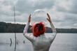 © Sergey Mironov/ADDICTIVE STOCK - Back view of unrecognizable futuristic young red haired female in silver space suit and glass helmet walking on flooding river