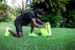© Sergio Victor Vega/ADDICTIVE STOCK - Side view of confident young African American male athlete with backpack in trendy sportswear getting ready to train in park with green tropical trees