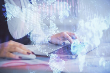 Double exposure of businesswoman hands typing on computer and forex graph hologram drawing. Financial analysis concept.