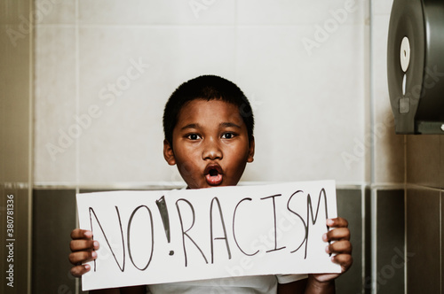 African american boy holding board No racism in toilet.No bully at school.Black boy kid.Bullying, discrimination and racism.Black lives matter activist movement protesting against racism and fighting.