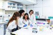 © MyMicrostock/Stocksy - Smiling scientists working at desk