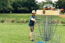 Man Throwing A Disk At A Basket Target Catcher