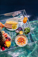 Floating breakfast at amazing hotel villa in blue swimming pool 