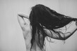 © Jess Craven/Stocksy - Skinny topless woman with cream background and long dark curly hair