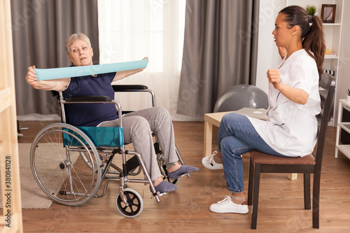 Fotografía Old lady in wheelchair training with elastic band