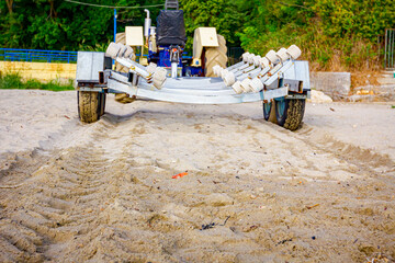 Wall Mural - Tractor with trailer for transport boats on the sandy beach