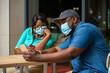 © AMO - image of black guy and a black lady looking on screen -African people with face mask-business conversation concept
