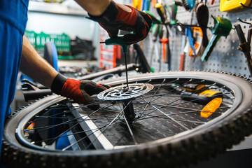 Bicycle assembly in workshop, man installs brake