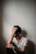 © Jess Craven/Stocksy - Male in white t-shirt sitting on floor and leaning against wall thinking