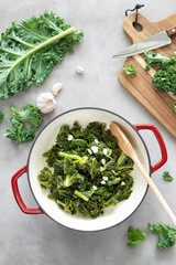 Sticker - Sauteed kale with garlic in cast iron pan on kitchen table, healthy food concept, superfood