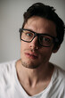 © Jess Craven/Stocksy - Male wearing dark frame glasses and white t-shirt