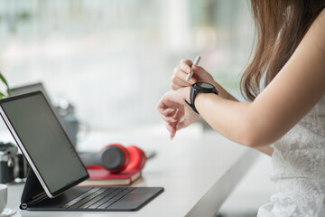 Leinwandbilder - Side view of female graphic designer working with digital tablet on computer desk in office room.