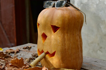 Halloween. The oblong pumpkin was turned into a festive monster by carving out its eyes, putting glasses on the pumpkin and putting a cigarette in its mouth.