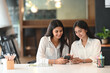 © Prathankarnpap - Young woman interior designers using smartphone discussing ideas for new project in office.