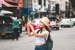 © dodotone - Young adult asian traveller women using mobile application for online social networ