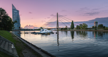 Riga city panorama with colorful sunset in the sky. Modern architecture meets old town. Picturesque view over riverside. 