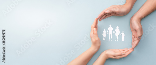 Fotografía Family care concept. Hands with paper silhouette on table.