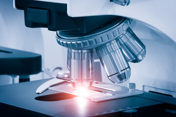 Poster - Close-up shot of microscope with metal lens at laboratory.