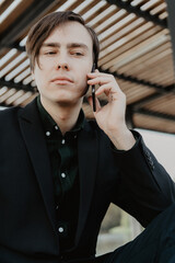 Wall Mural - White young man holds a smartphone in his hand. Selective focus.