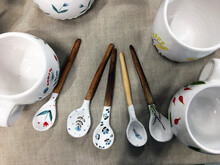 Handmade Ceramic Spoons With Wooden Handle On Linen. Home And Kitchen Decor, Pottery Gift. Antique Vintage Multicolored Tableware. Hand-painted Cups With Children Drawings. 