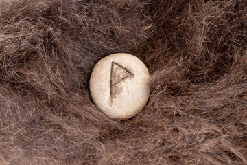 Wunjo Nordic stone rune on animal fur. Letter Wyn of the Viking alphabet.