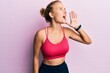 © Krakenimages.com - Beautiful caucasian woman wearing sportswear shouting and screaming loud to side with hand on mouth. communication concept.