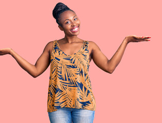 Wall Mural - Young african american woman wearing casual clothes smiling showing both hands open palms, presenting and advertising comparison and balance