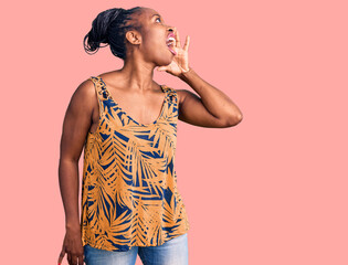 Wall Mural - Young african american woman wearing casual clothes shouting and screaming loud to side with hand on mouth. communication concept.