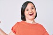 © Krakenimages.com - Brunette woman with down syndrome wearing casual clothes celebrating victory with happy smile and winner expression with raised hands