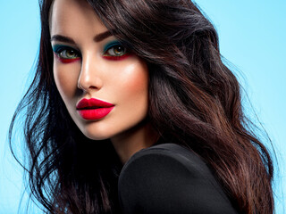 Wall Mural - portrait of beautiful young woman with bright blue makeup. beautiful brunette with bright red lipsti