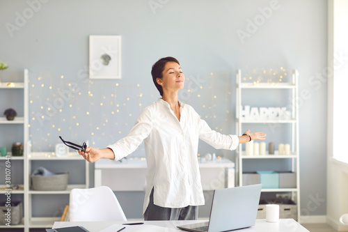 Fotografía Happy relaxed business woman doing breathing exercises during break in her home