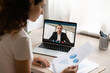 © fizkes - Rear view of female employee have webcam virtual conference or digital online meeting with male boss discuss paperwork together. Woman worker brainstorm talk on video call with director on web.
