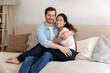 © fizkes - Portrait of happy young Caucasian man and woman tenants relax on sofa in cozy living room in new home. Smiling couple renters rest on couch, enjoy family weekend in own house. Realty concept.