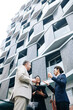 © DragonImages - Multi-ethnic group of business people standing outside the modern office building and discussing ideas