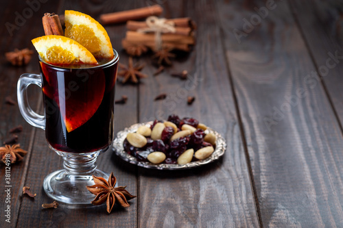Fotomural Red glogg or mulled wine with orange slices and cinnamon stick on dark wooden ba