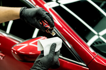 Car service worker applying nano coating on a car detail.