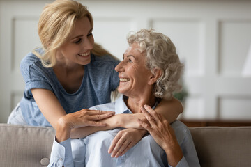 Kindred souls. Two best friends women of different generations, elder mature grandma or mom and young adult daughter or grandchild hugging close together, understand each other, having same interests