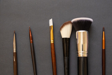 Wall Mural - makeup brush on a dark background close up