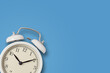 © Lazy_Bear - White vintage alarm clock on a blue background. Urgency, deadline and running out of time concept