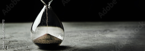 Cuadros en Lienzo Hourglass on a dark background, long banner
