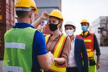 Worker Scanning Fever Temperature With Digital Thermometer To Construction Site Staff Wearing Hygiene Face Mask Protect From Coronavirus Or COVID-19. New Normal Working Life Adaptation In 2020