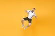 © ViDi Studio - Full length portrait of excited cheerful young bearded man 20s wearing white shirt shorts posing jumping stretching suspender looking camera isolated on bright yellow color wall background studio.