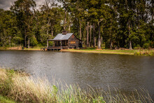 Scenic View Of The Exterior Of A Rural Rustic Wooden Camp House Used For Fishing And Hunting. The House Is Located On A Large Pond