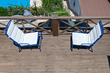 wooden terrace of holiday villa or hotel with two white chair and sea view